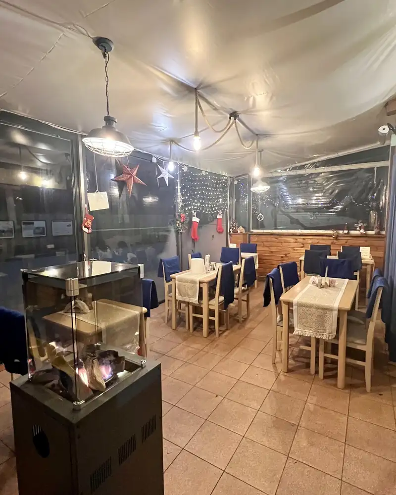 Zadaszony taras ze stolikami i lampami